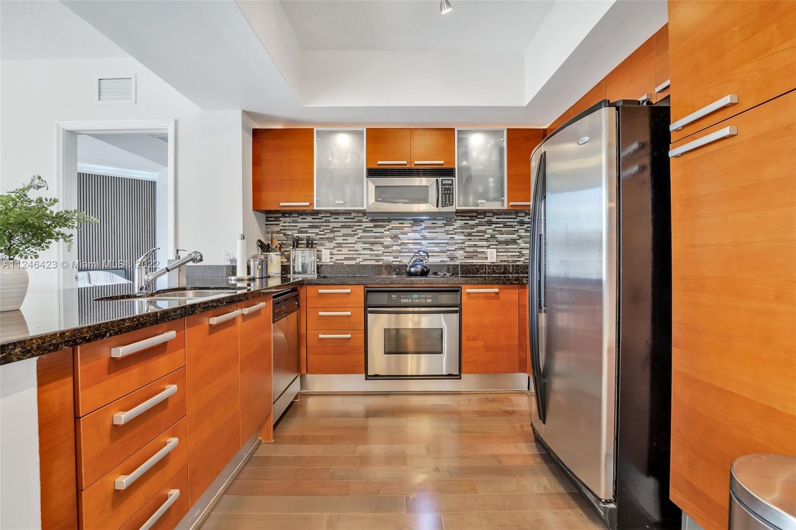 2030 Douglas Road, Unit 817 Coral Gables, FL 33134 - Photo 6 of 28 a large kitchen with stainless steel appliances granite countertop a refrigerator and a sink