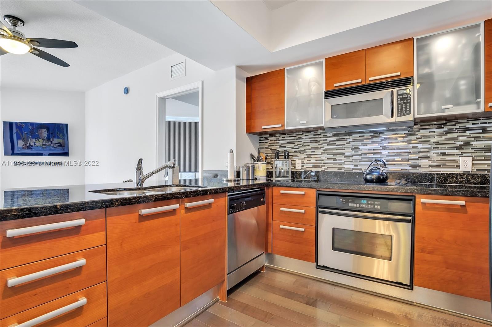 2030 Douglas Road, Unit 817 Coral Gables, FL 33134 - Photo 7 of 28 a kitchen with stainless steel appliances granite countertop a stove and a sink