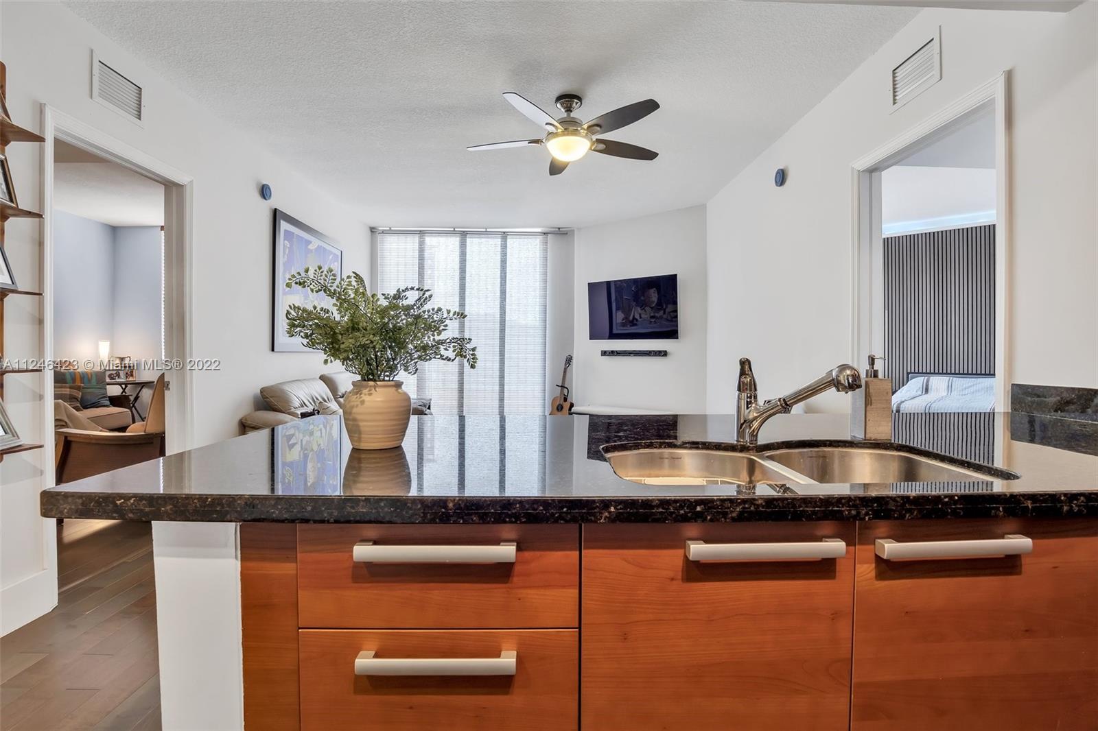 2030 Douglas Road, Unit 817 Coral Gables, FL 33134 - Photo 8 of 28 a kitchen with granite countertop a sink a counter top space and living room