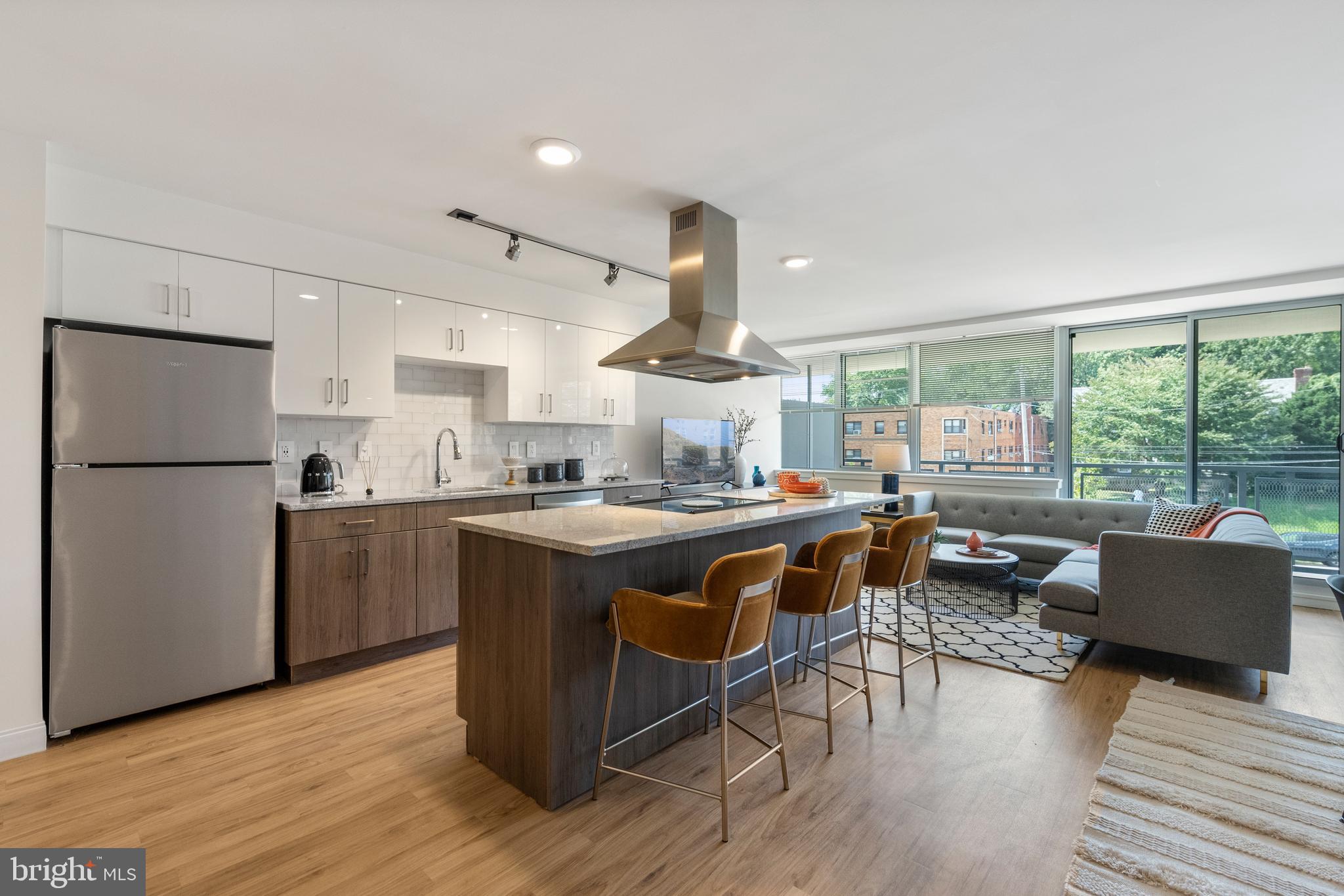 a kitchen with kitchen island wooden floors and stainless steel appliances