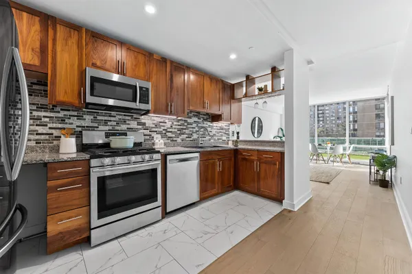 a kitchen with stainless steel appliances granite countertop a stove a sink and a microwave