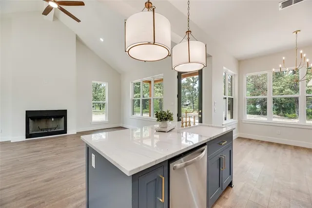 a kitchen with granite countertop a stove a sink and a large window