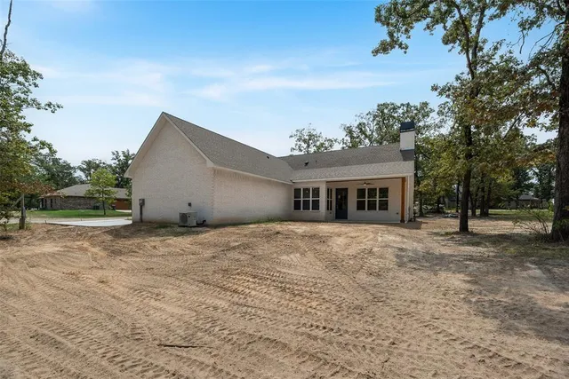 a front view of a house with a yard and trees