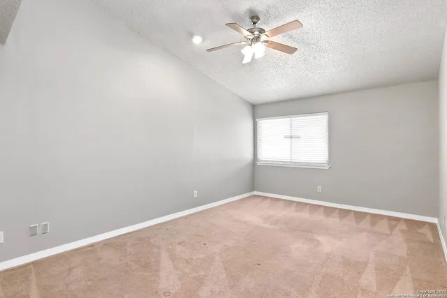 an empty room with a window and a fan