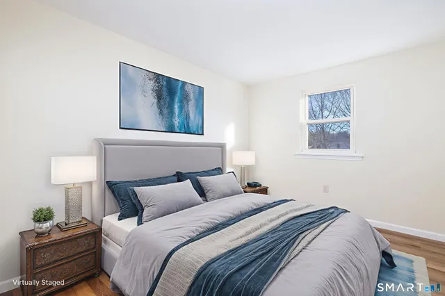 a bedroom with a bed and a lamp on the dresser