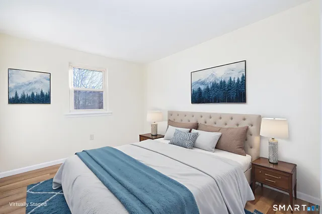 a bedroom with a bed and a wall painting