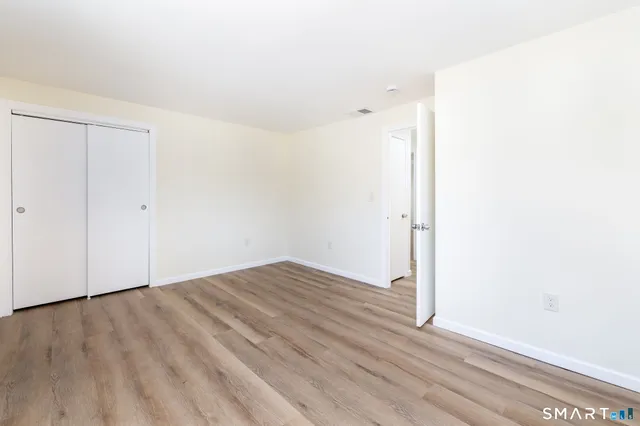 a view of an empty room with wooden floor