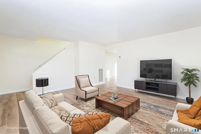 a living room with furniture flat screen tv and a couch