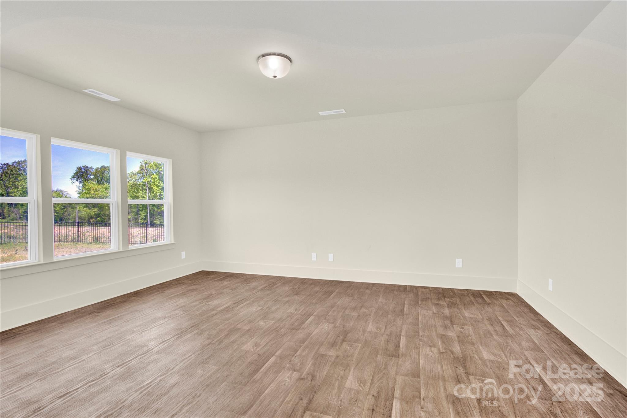 207 Aspire Circle, Unit 46 Wingate, NC 28174 - Photo 14 of 34 an empty room with wooden floor and windows