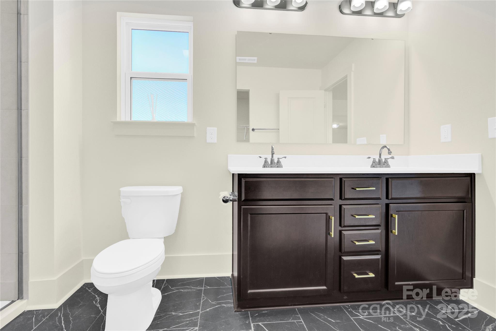 207 Aspire Circle, Unit 46 Wingate, NC 28174 - Photo 25 of 34 a bathroom with a toilet sink and mirror