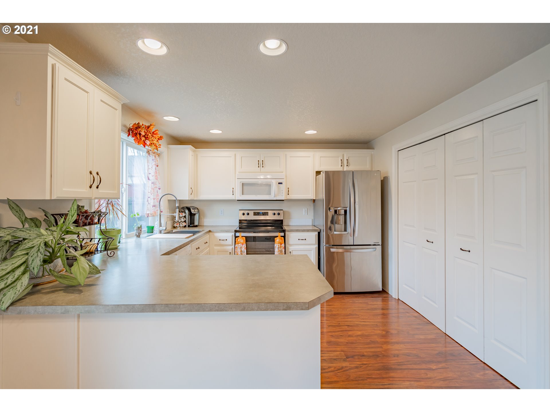 2051 North 9th Way Ridgefield, WA 98642 - Photo 8 of 32 a kitchen with stainless steel appliances granite countertop a refrigerator a oven a sink dishwasher and white cabinets with wooden floor