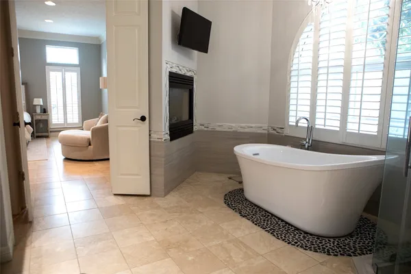 a white tub sitting in a spacious bathroom next to a window