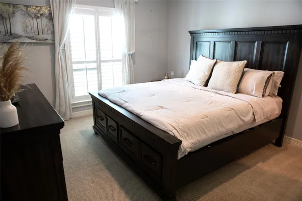 a large bed sitting in a bedroom next to a window