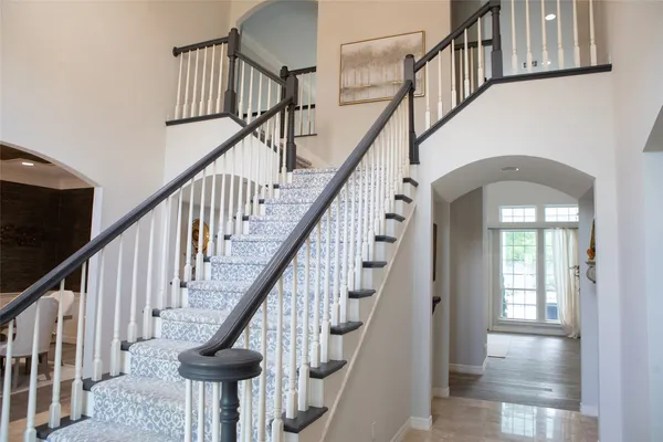 a view of staircase with wooden floor and a chandelier