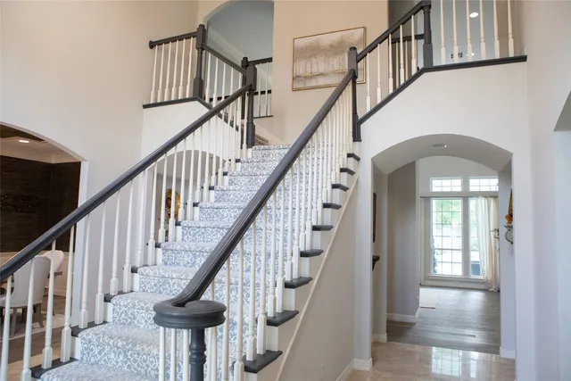 a view of staircase with wooden floor and a chandelier