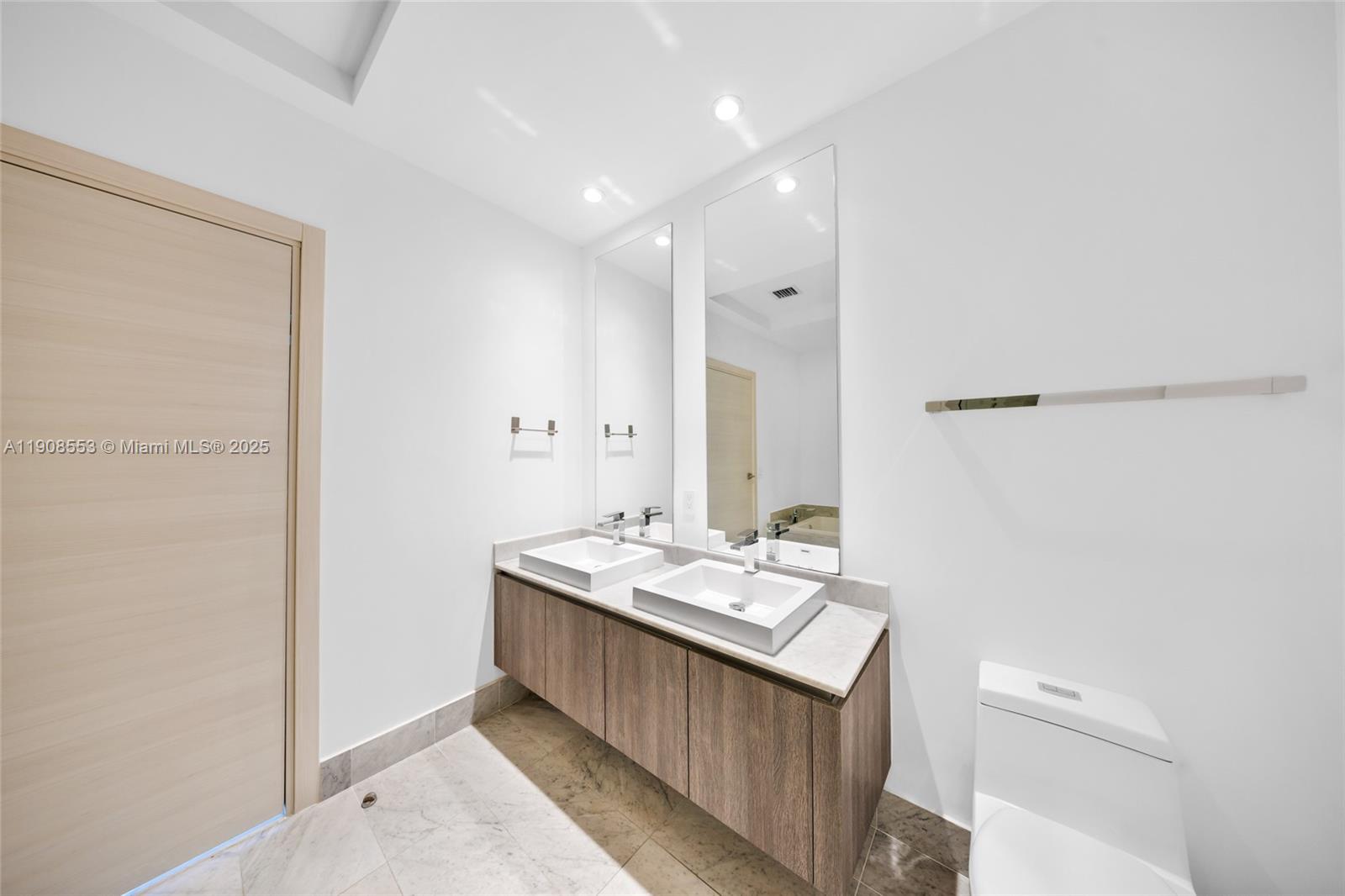 801 South Miami Avenue, Unit 5204 Miami, FL 33131 - Photo 15 of 31 a bathroom with a sink a mirror and a toilet