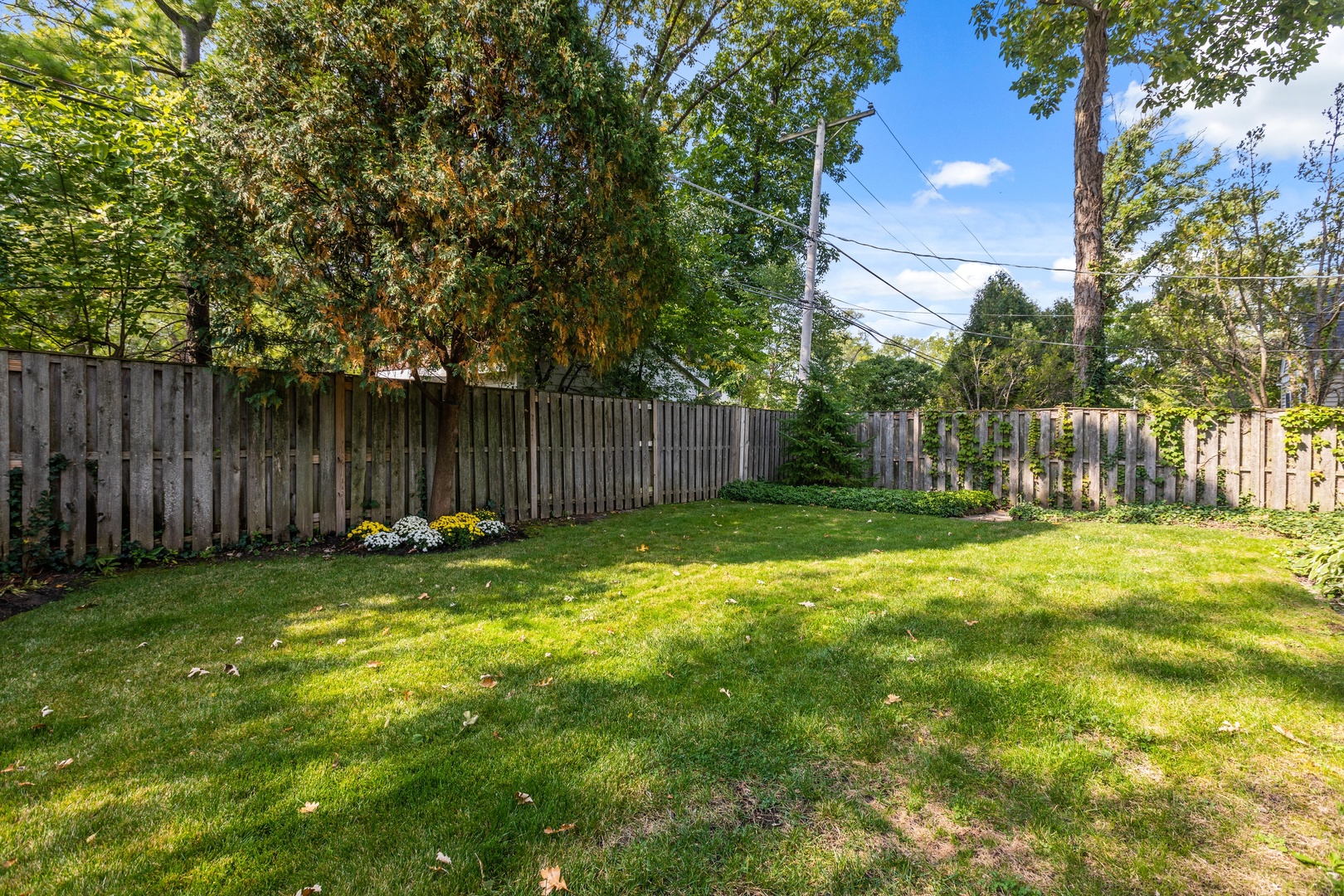 258 Wagner Road Northfield, IL 60093 - Photo 16 of 17 a view of a backyard with table and chairs and wooden fence
