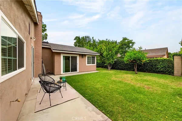a view of a backyard with table and chairs with wooden fence and plants