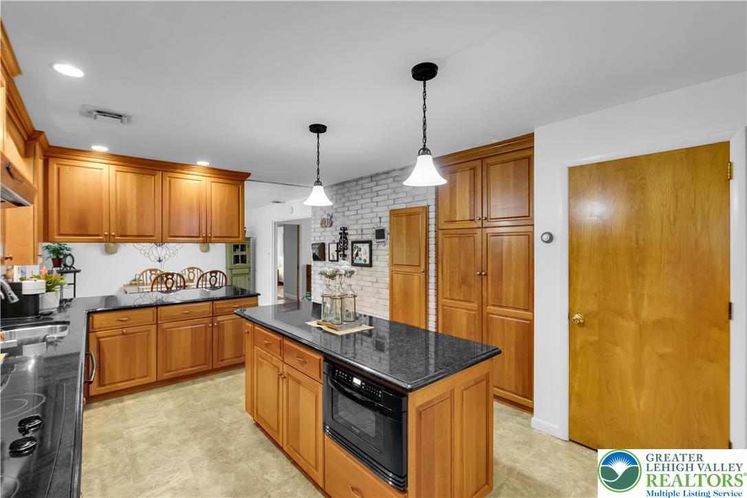 5747 Kernsville Road Orefield, PA 18069 - Photo 15 of 56 a kitchen with stainless steel appliances granite countertop a sink refrigerator and cabinets