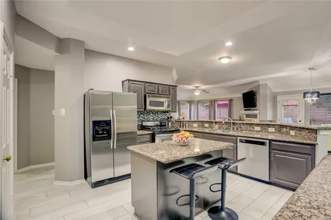 a kitchen with kitchen island a sink stove and refrigerator