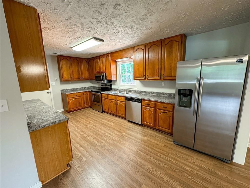 774 Mill Road McDonough, GA 30253 - Photo 7 of 37 a kitchen with stainless steel appliances granite countertop wooden floors and granite counter tops