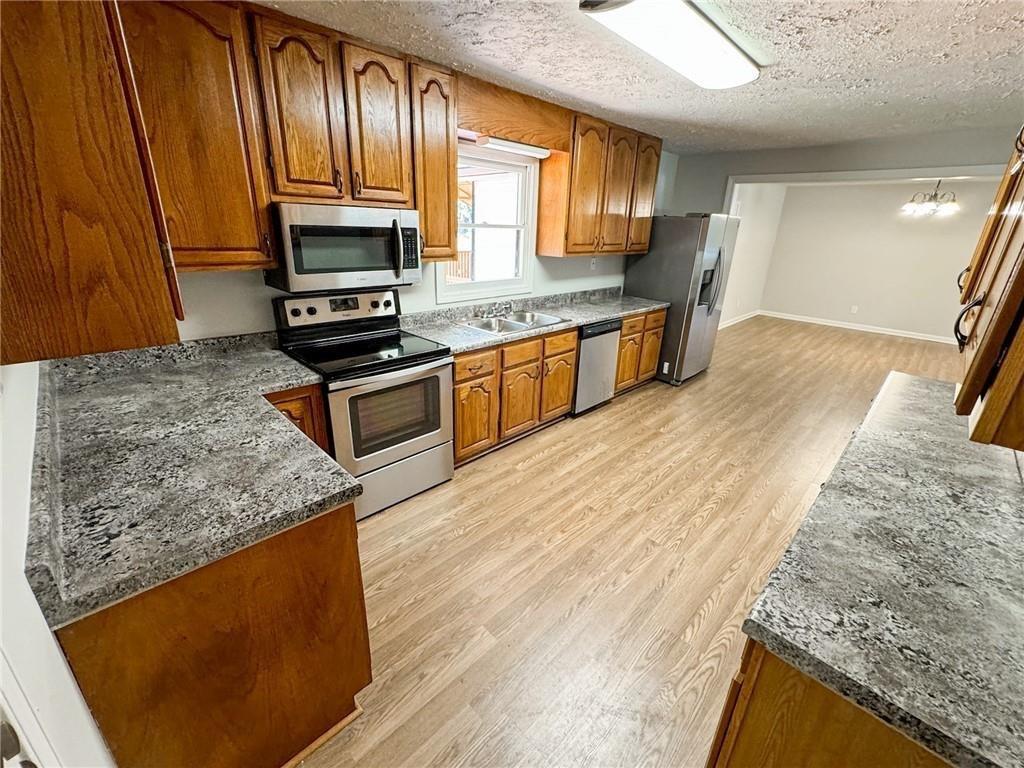 774 Mill Road McDonough, GA 30253 - Photo 8 of 37 a kitchen with stainless steel appliances granite countertop wooden cabinets a stove top oven a sink and dishwasher