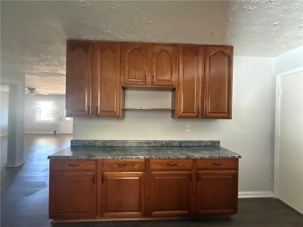 774 Mill Road McDonough, GA 30253 - Photo 9 of 37 a living room with granite countertop wooden cabinets and a wooden floor