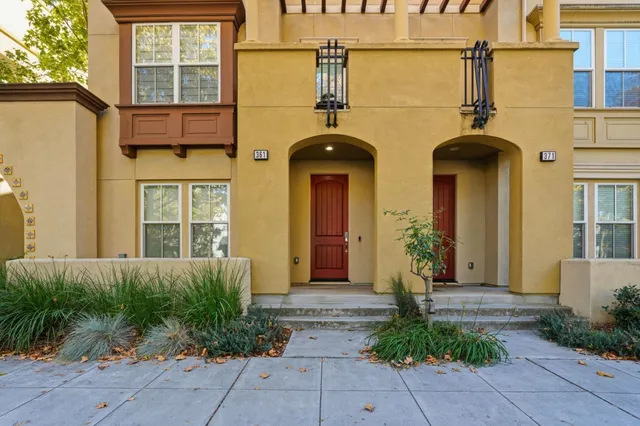 front view of a brick house with potted plants