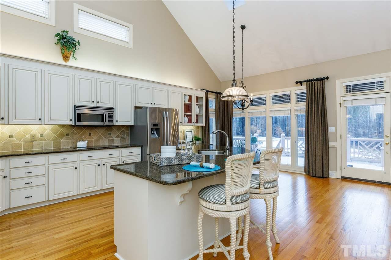 2968 Tillinghast Trail Raleigh, NC 27613 - Photo 4 of 28 a kitchen with sink refrigerator dining table and chairs