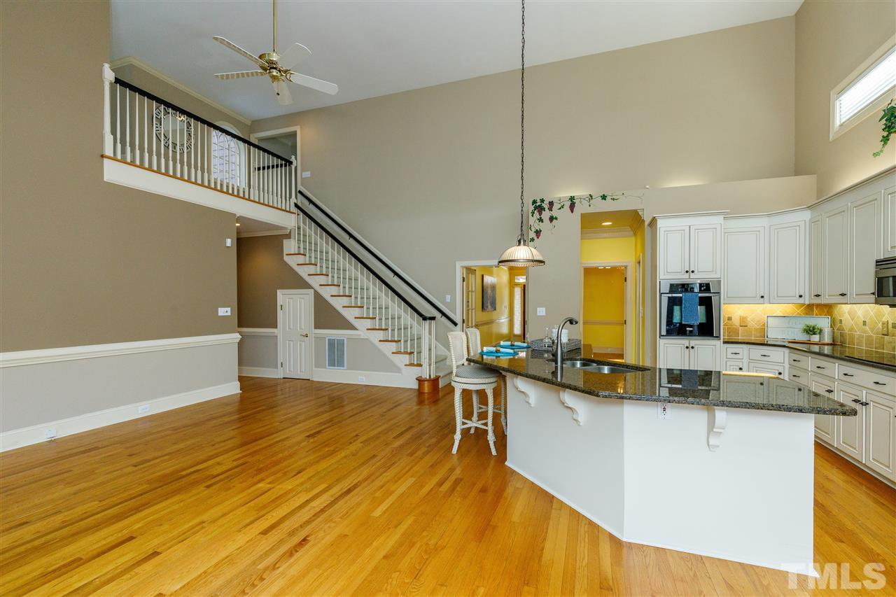 2968 Tillinghast Trail Raleigh, NC 27613 - Photo 7 of 28 a view of a kitchen with kitchen island stainless steel appliances wooden floor and living room view