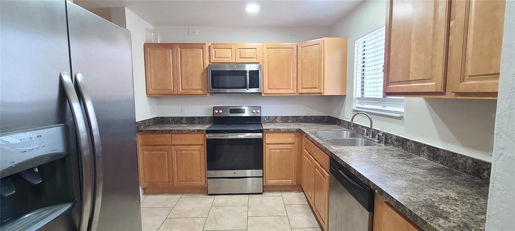 1304 Deer Springs Road Port Orange, FL 32129 - Photo 11 of 37 a kitchen with stainless steel appliances granite countertop a sink stove and refrigerator