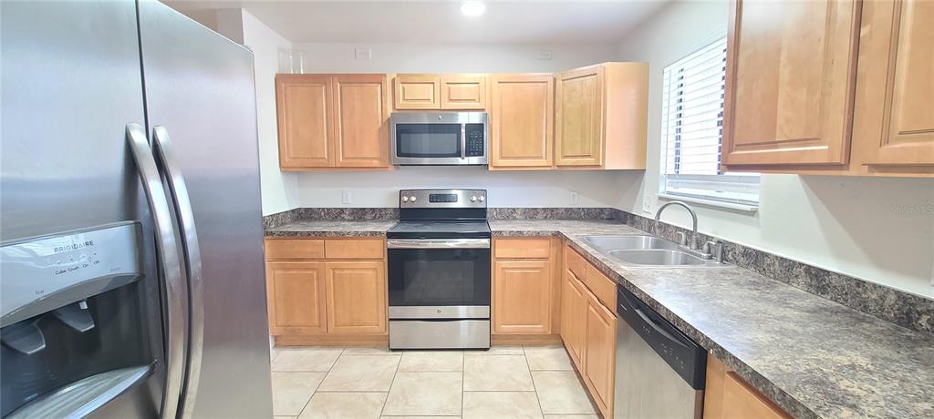 1304 Deer Springs Road Port Orange, FL 32129 - Photo 12 of 37 a kitchen with stainless steel appliances granite countertop a sink stove and refrigerator