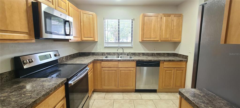1304 Deer Springs Road Port Orange, FL 32129 - Photo 8 of 37 a kitchen with stainless steel appliances granite countertop a sink stove and cabinets