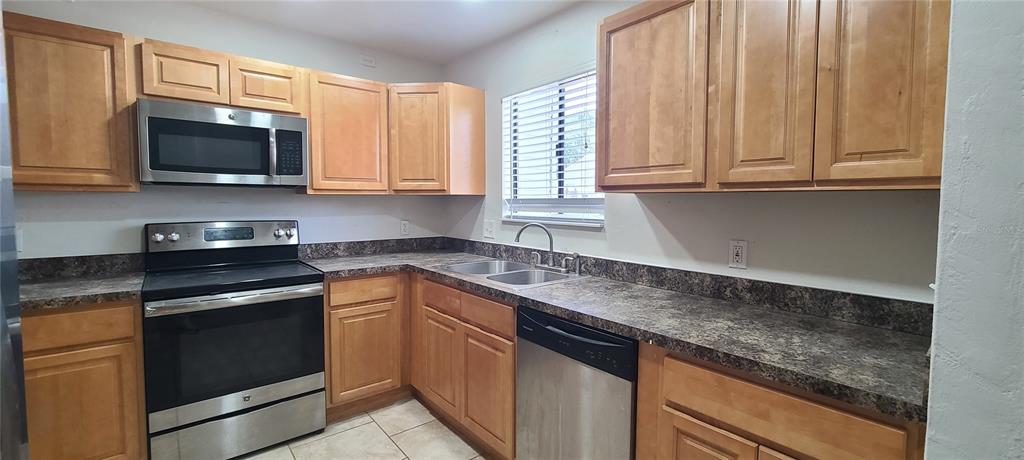 1304 Deer Springs Road Port Orange, FL 32129 - Photo 10 of 37 a kitchen with stainless steel appliances granite countertop white cabinets and a stove top oven