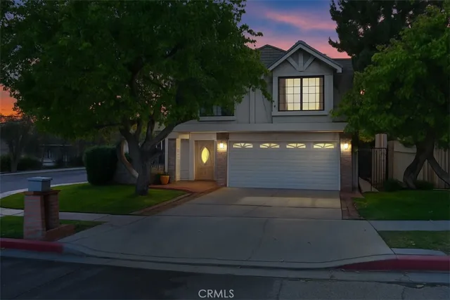 a front view of a house with yard and green space