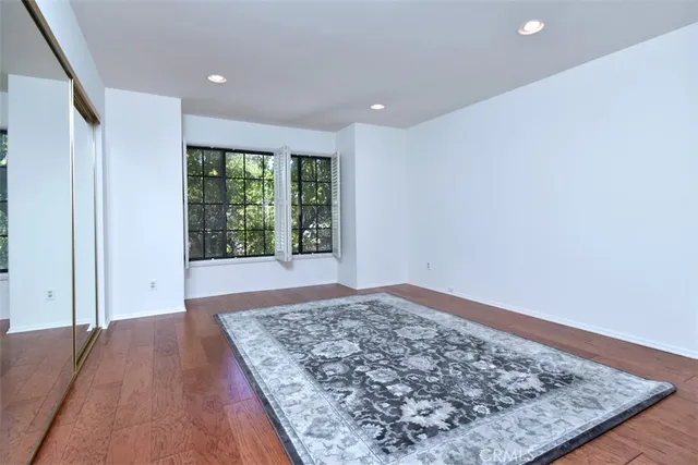 an empty room with wooden floor and window