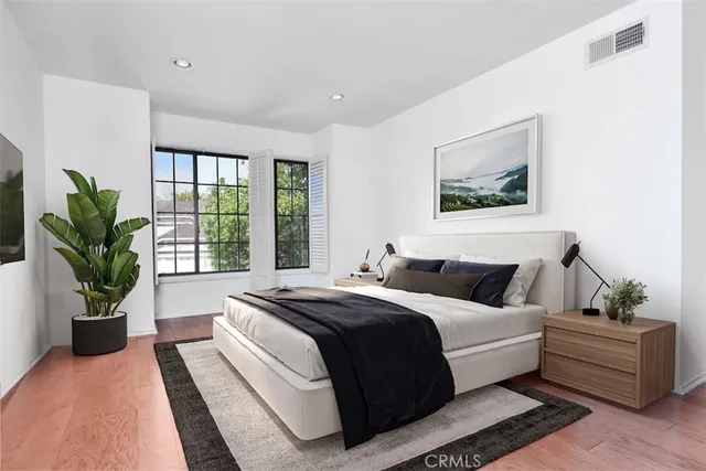 a bedroom with a large bed and a potted plant