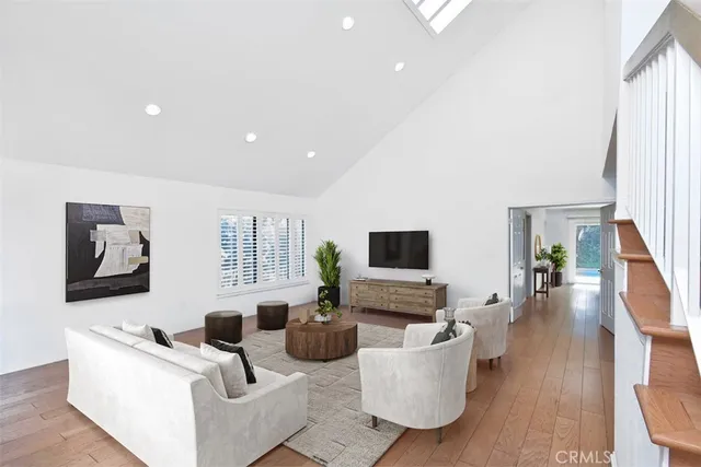 a living room with furniture a flat screen tv a rug and a window