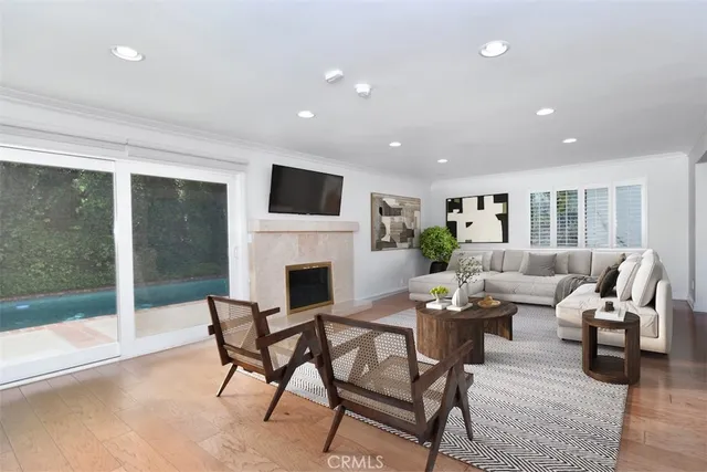 a living room with furniture a fireplace and a floor to ceiling window