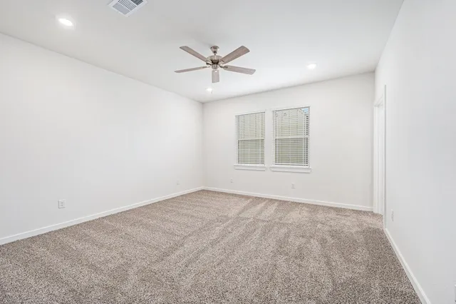 an empty room with closet and ceiling fan