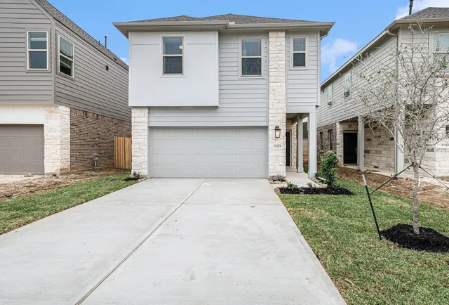 a front view of a house with a yard and garage