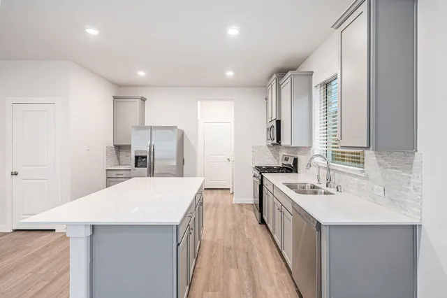 a kitchen with white cabinets and appliances