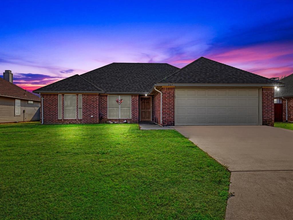207 Quail Run Aubrey, TX 76227 - Photo 2 of 30 Ranch-style home with roof with shingles, a front lawn, brick siding, a garage, and driveway
