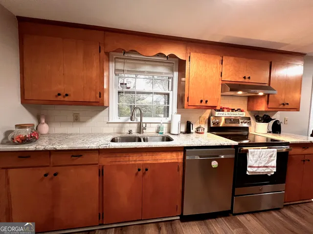 a kitchen with stainless steel appliances granite countertop a sink stove and microwave