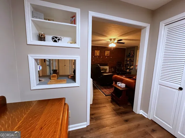 a view of a hallway with wooden floor fireplace and dining room