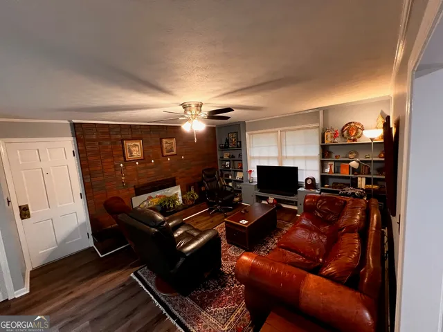 a living room with furniture a flat screen tv and a window