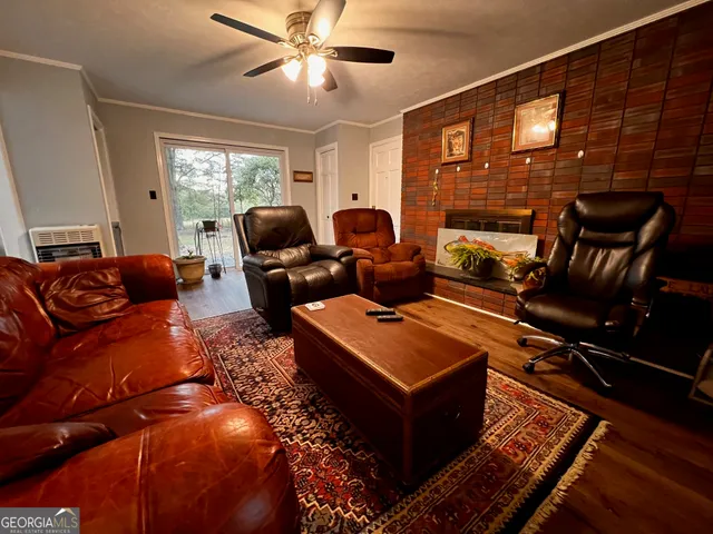 a living room with furniture a ceiling fan and a window