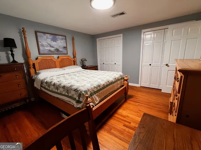 a bed sitting in a bedroom and wooden floor