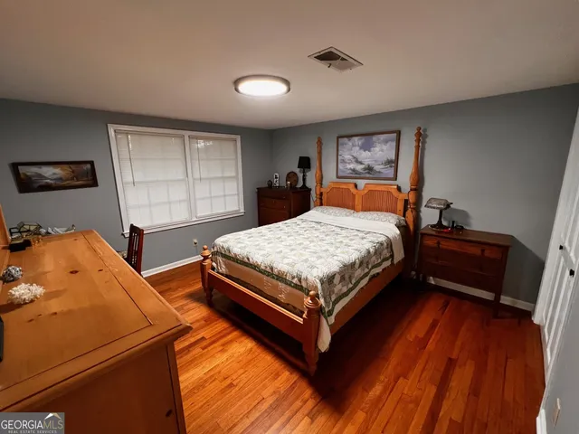 a bedroom with a bed and wooden floor
