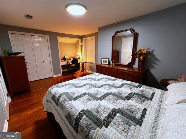 a bedroom with a bed and a mirror on dresser